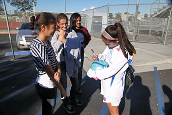 Nichols autographs soccer ball for group of fans