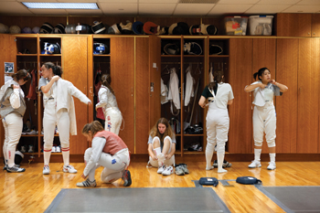 Womens fencing team members suit up before a practice