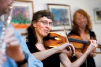 Kathy Selby plays fiddle during party at home