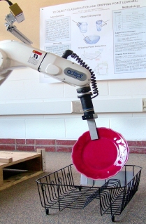 Robotic arm places dish in dish rack