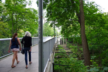 People walk across the footbridge connecting Collegetown to campus