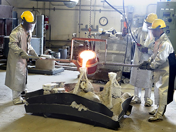 Molten bronze is poured into parts of the Touchdown statue mold in Farmingdale, New York.