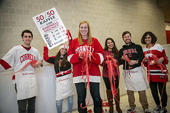 Cornell Tradition fellow Suzannah Bretz '17, center, along with other fellows, sells raffle tickets at a Big Red hockey game at Lynah Rink.