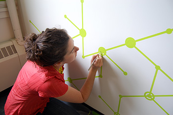 Leah Scolere paints designs on center's walls in Caldwell Hall