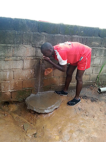 Franck Onambélé tastes water from the fountain