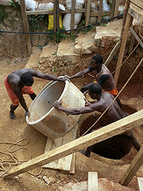 workers install concrete pipes in Cameroon
