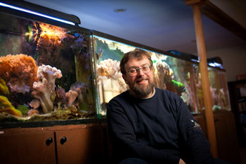 Jarek Pillardy with fish tanks in his basement